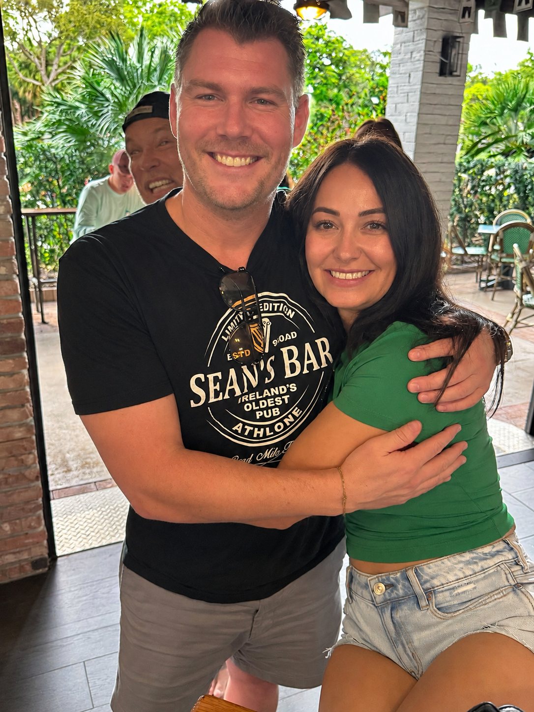 Ryan and Wendy hugging on a patio