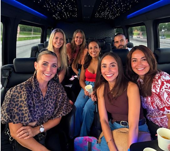 Wendy and friends smiling together in a party van