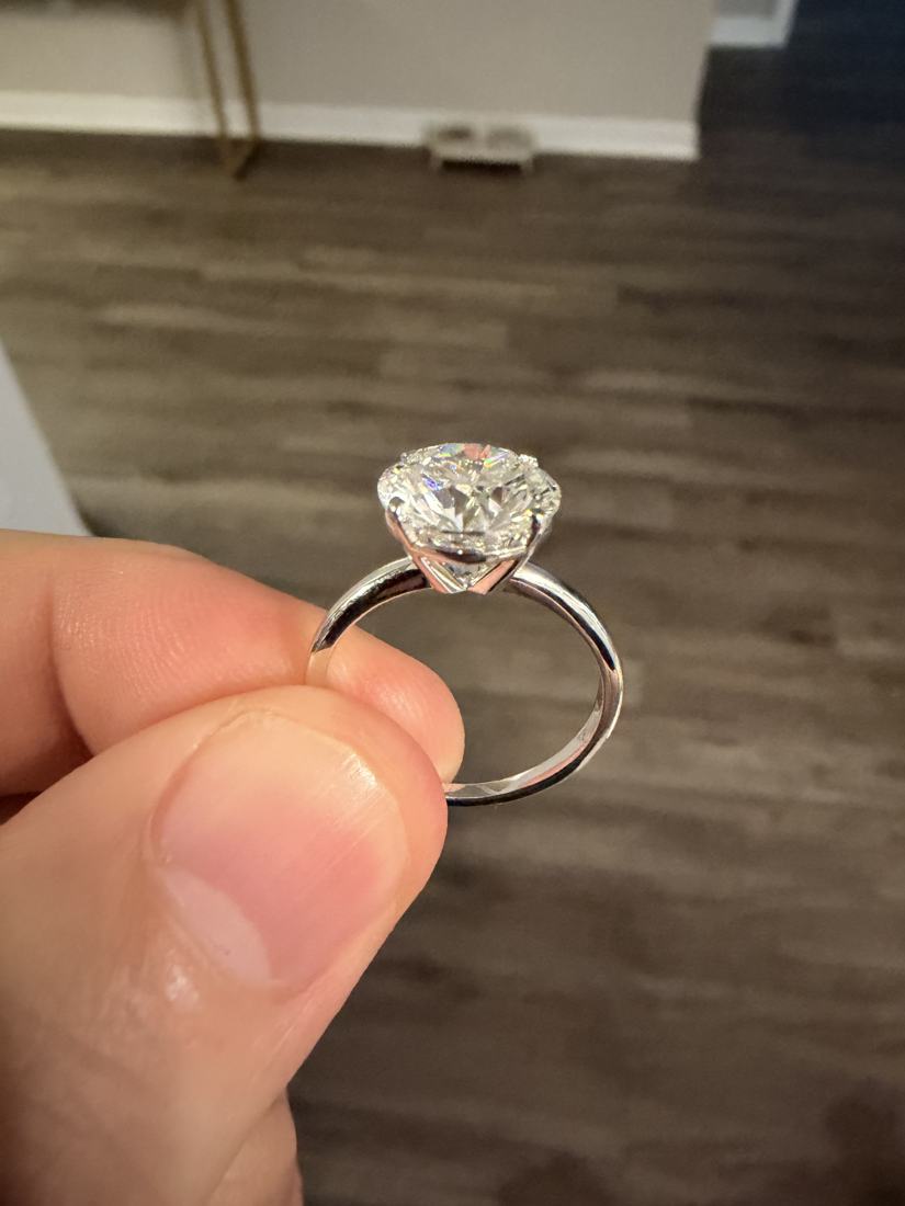 The engagement ring held up to the light