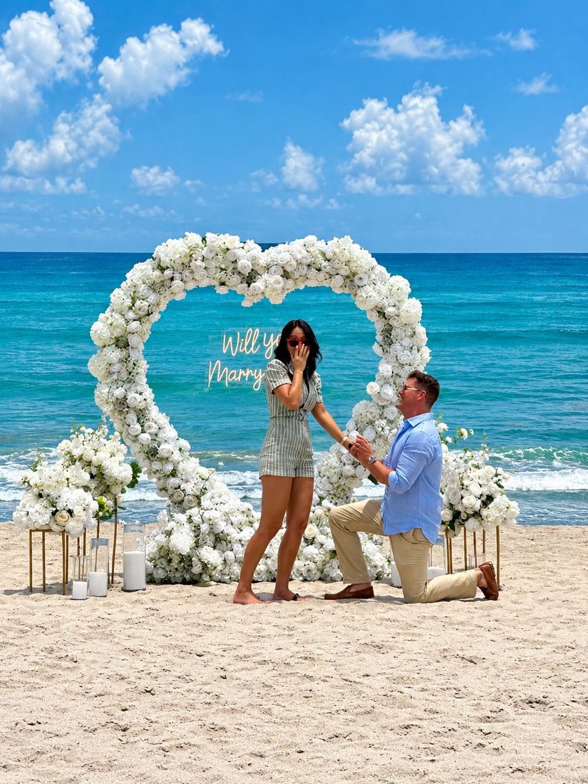 Ryan on one knee asking Wendy to marry him beneath the floral heart, Wendy covering her mouth in surprise