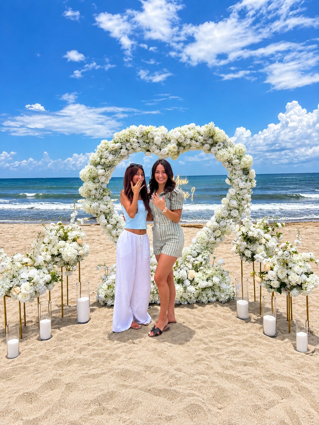 Wendy and a friend under the floral heart on the beach